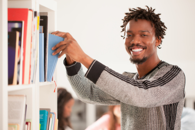 smiling man taking a book from the library